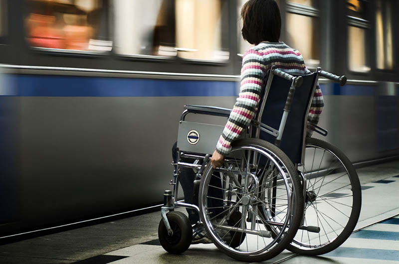 person in wheelchair catching train