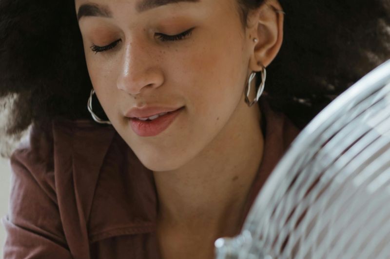 person keeping cool with fan